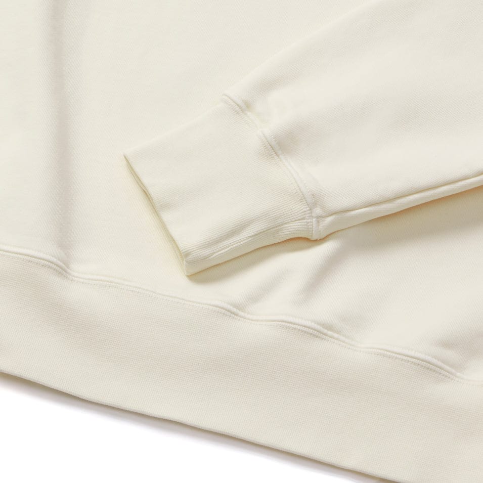 Cream-colored sweatshirt sleeve and hem.