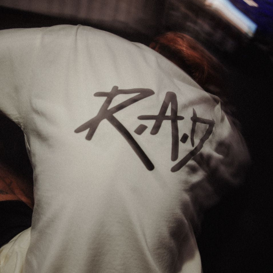 White t-shirt with ’RAD’ graphic.