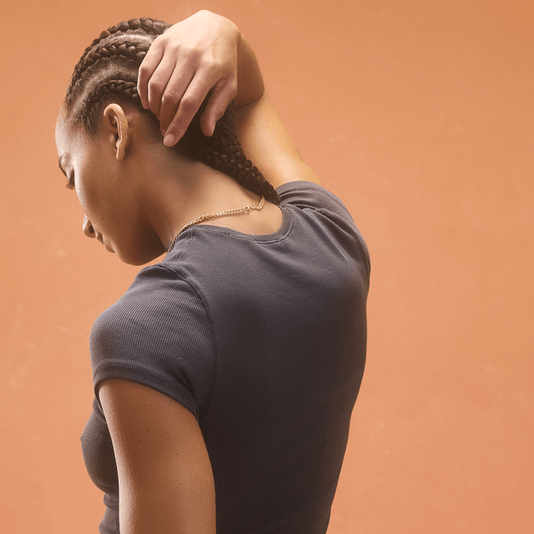 Woman with braided hair wearing a gray shirt.